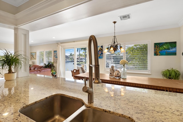 details with visible vents, a sink, decorative light fixtures, crown molding, and a chandelier