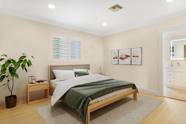 bedroom featuring light wood-style flooring, baseboards, visible vents, and ornamental molding