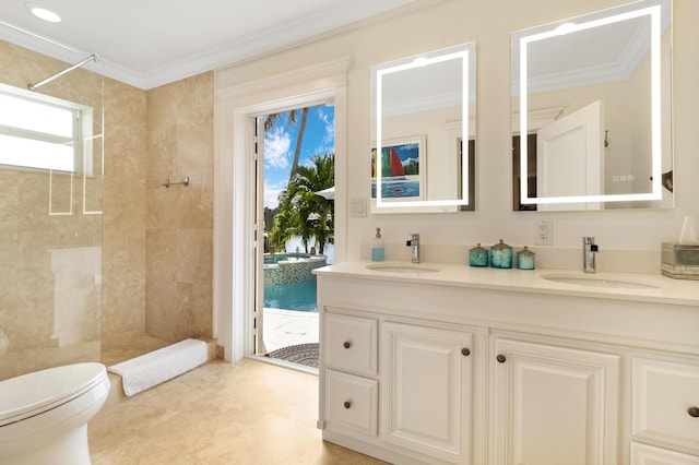 bathroom featuring tiled shower, crown molding, and a sink