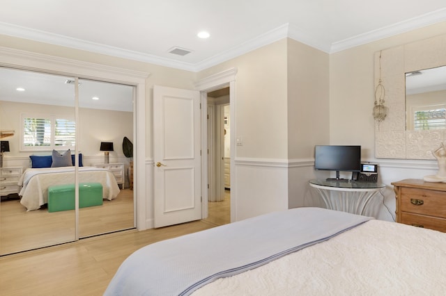 bedroom with visible vents, multiple windows, light wood-style floors, and ornamental molding