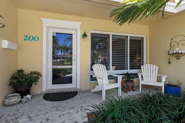 entrance to property featuring a patio area and stucco siding