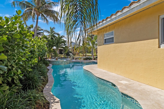 view of pool with a pool with connected hot tub