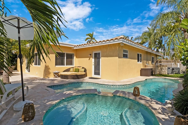 view of pool featuring a pool with connected hot tub, a patio, and fence