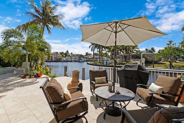 view of patio / terrace with an outdoor living space, a water view, and grilling area