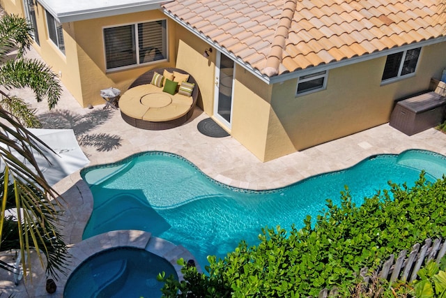 outdoor pool with an in ground hot tub and a patio area