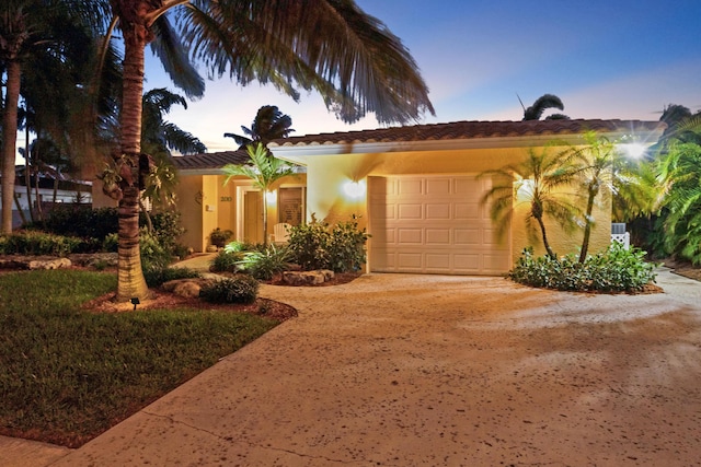 view of front of home featuring a garage, driveway, and stucco siding