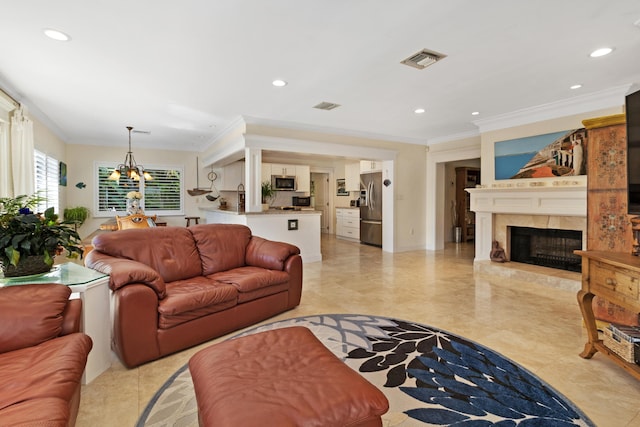 living area featuring visible vents, an inviting chandelier, ornamental molding, and a fireplace