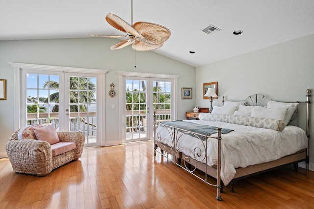 bedroom with lofted ceiling, visible vents, light wood-style floors, access to outside, and french doors