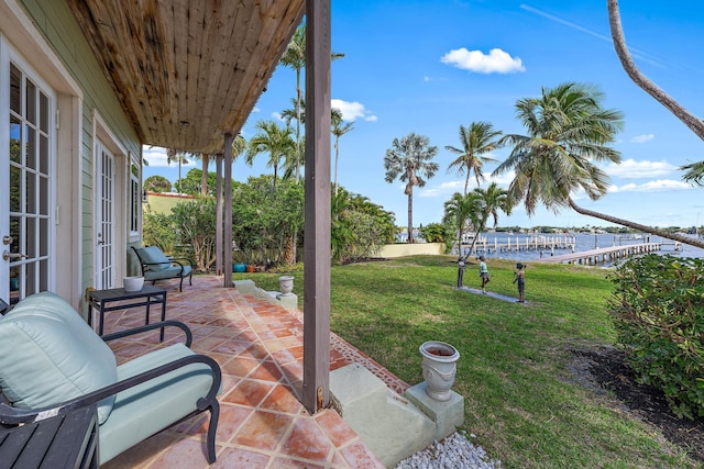 view of patio / terrace featuring a water view and fence