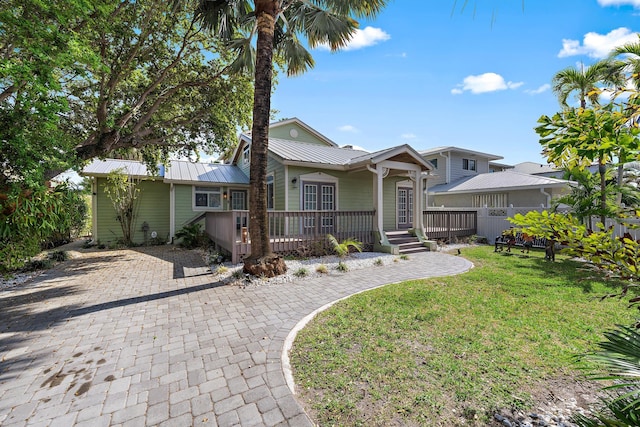 back of property featuring metal roof and a yard