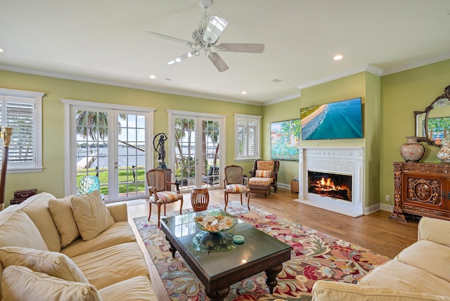 living room with a fireplace with flush hearth, ornamental molding, wood finished floors, and french doors