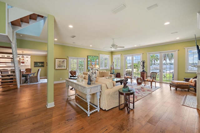living room featuring french doors, visible vents, baseboards, and wood finished floors