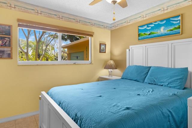 bedroom with light tile patterned floors, baseboards, and a textured ceiling