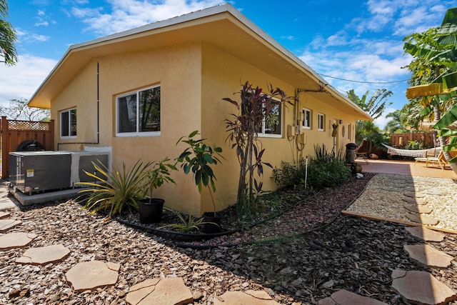 view of property exterior featuring fence and stucco siding