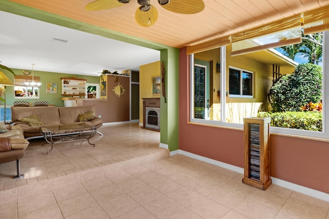 interior space featuring light tile patterned floors, a fireplace, visible vents, and baseboards