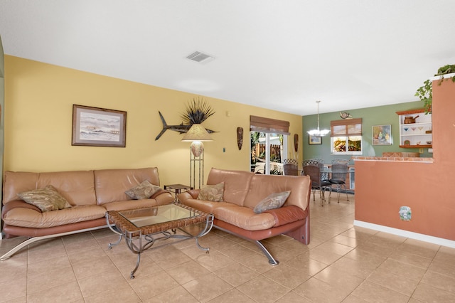 living room featuring light tile patterned floors, visible vents, and an inviting chandelier