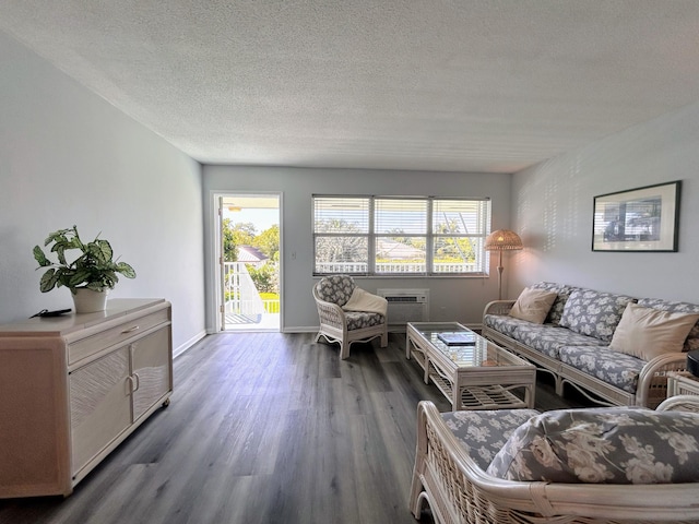 living area featuring a textured ceiling, baseboards, and wood finished floors