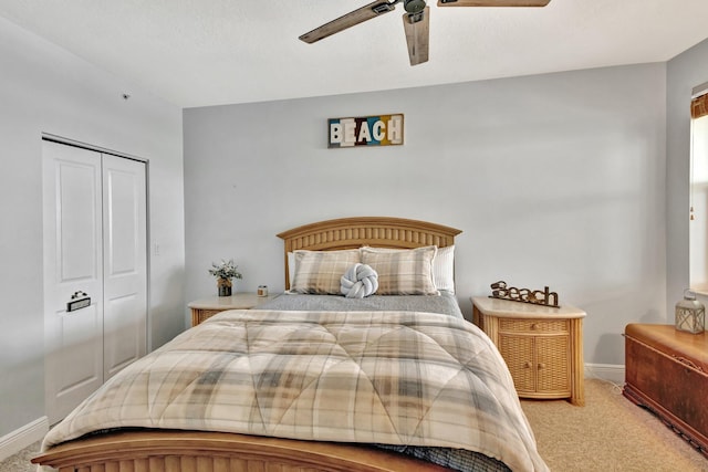 carpeted bedroom with ceiling fan, baseboards, and a closet