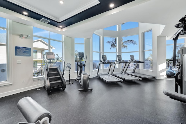 workout area with recessed lighting, visible vents, baseboards, ornamental molding, and a tray ceiling