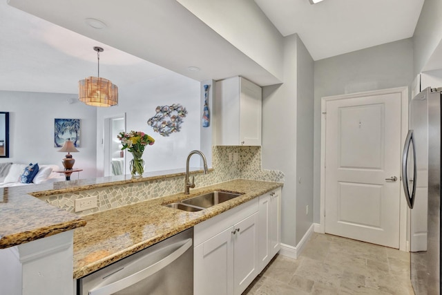 kitchen featuring backsplash, white cabinetry, stainless steel appliances, and a sink