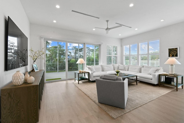 living area featuring light wood finished floors, ceiling fan, visible vents, and recessed lighting