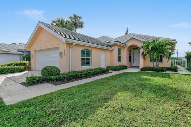 view of front of home featuring stucco siding, concrete driveway, an attached garage, a front yard, and a tiled roof