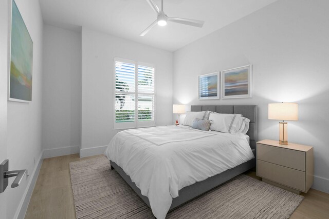 bedroom with light wood-style floors, ceiling fan, and baseboards