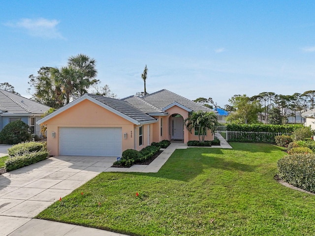 view of front of property featuring driveway, an attached garage, fence, a front lawn, and stucco siding