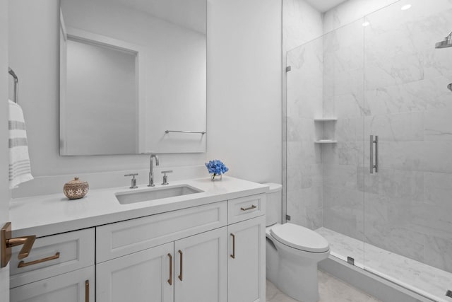 bathroom with a stall shower, vanity, and toilet