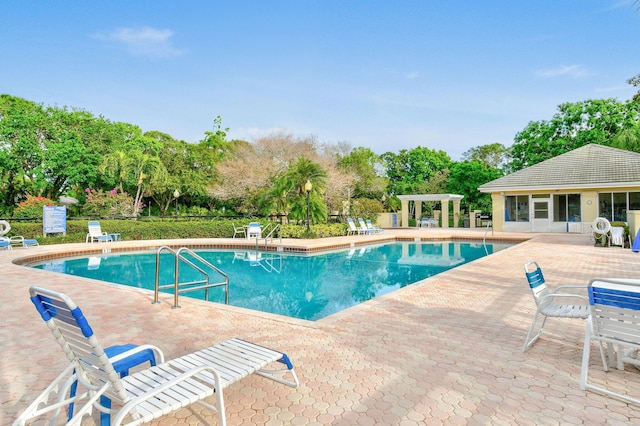 community pool with fence, an outbuilding, a pergola, and a patio