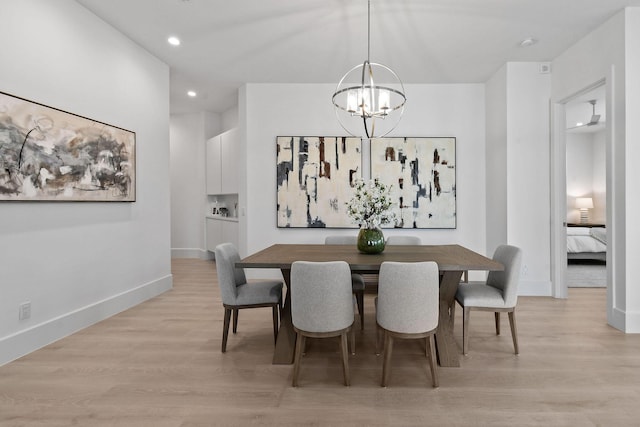 dining room with recessed lighting, light wood-style flooring, baseboards, and an inviting chandelier