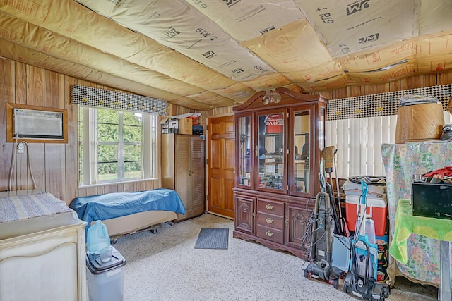 bedroom with vaulted ceiling, a wall mounted air conditioner, and wood walls