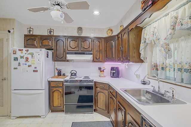 kitchen with black range with electric stovetop, freestanding refrigerator, light countertops, under cabinet range hood, and a sink