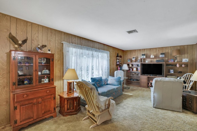 living area featuring visible vents, wooden walls, and carpet flooring