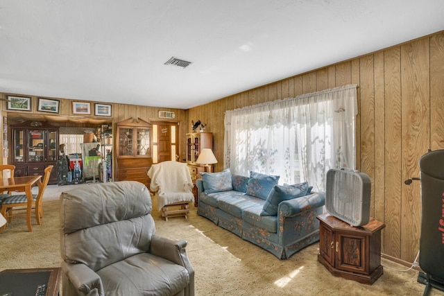 living room featuring carpet floors, wood walls, and visible vents