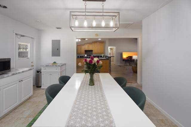 dining room featuring baseboards, electric panel, and visible vents