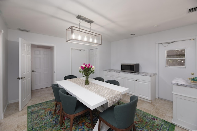 dining room with stone finish floor, baseboards, and visible vents