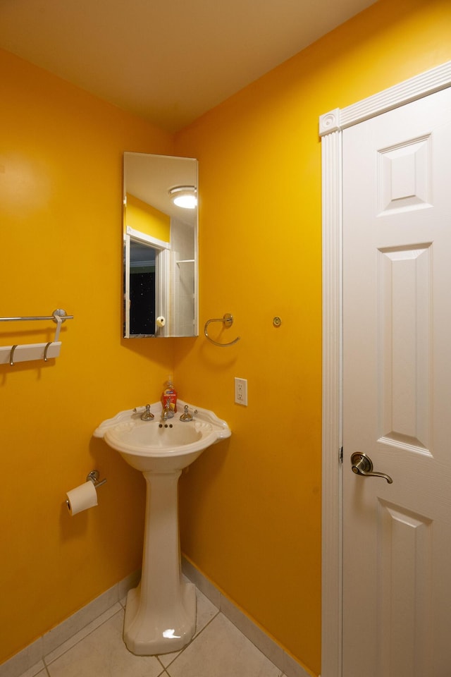 bathroom with a sink, tile patterned flooring, and baseboards