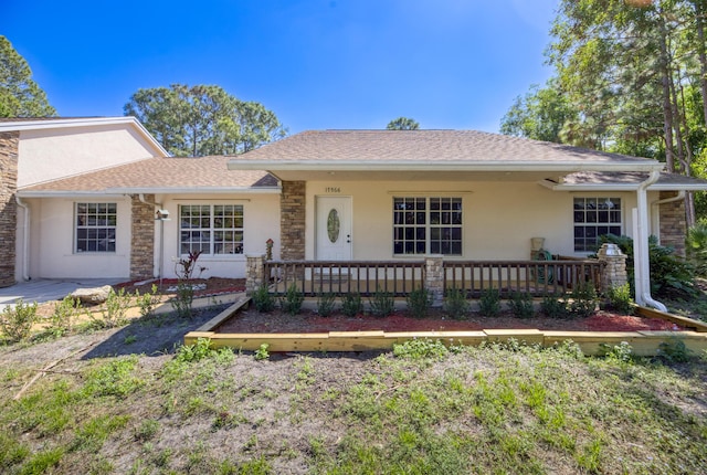 single story home with covered porch, roof with shingles, and stucco siding