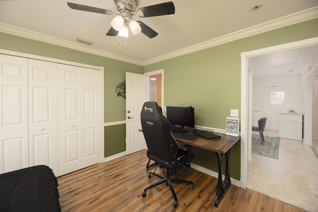 office space with attic access, visible vents, crown molding, and wood finished floors