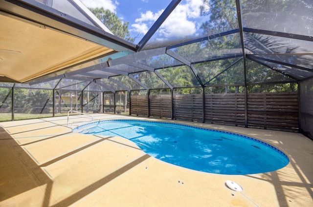 view of swimming pool featuring a fenced in pool, glass enclosure, a patio area, and fence