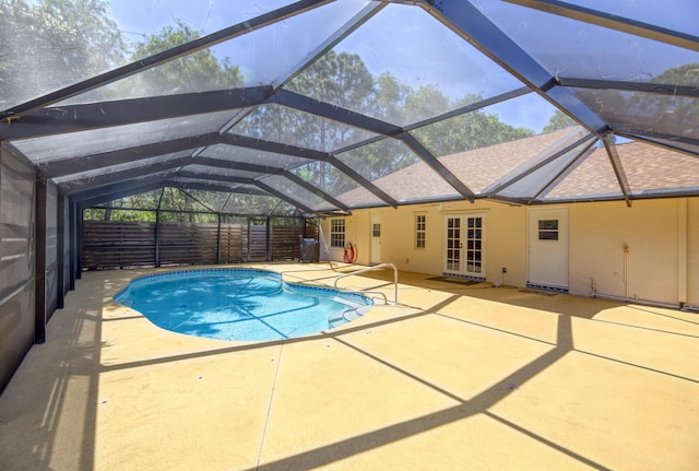 pool featuring a lanai, a patio area, fence, and french doors