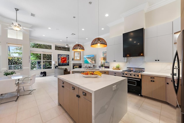 kitchen featuring visible vents, a kitchen island, open floor plan, freestanding refrigerator, and high end range