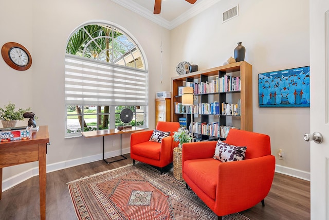 sitting room featuring visible vents, crown molding, baseboards, wood finished floors, and a ceiling fan