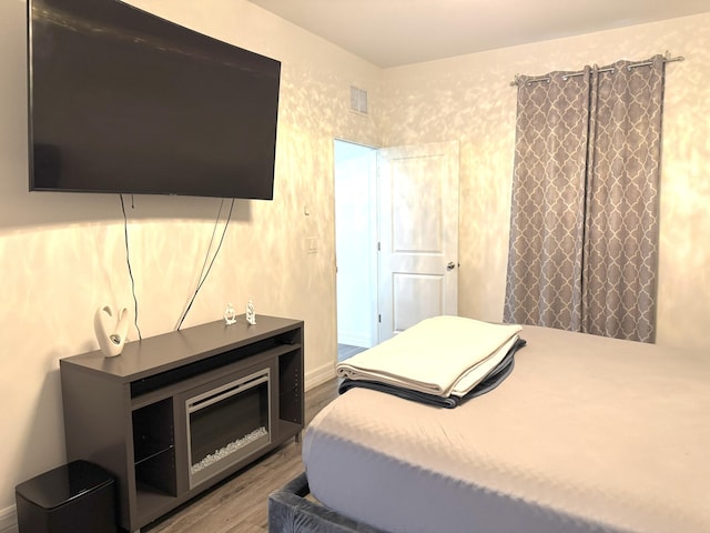 bedroom with visible vents and wood finished floors