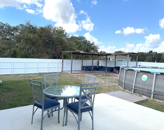 view of patio with outdoor dining space, a fenced backyard, and a fenced in pool