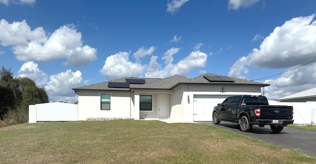 view of front facade featuring a garage, fence, driveway, stucco siding, and a front yard