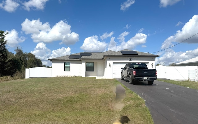 view of front facade featuring aphalt driveway, a front lawn, an attached garage, and fence