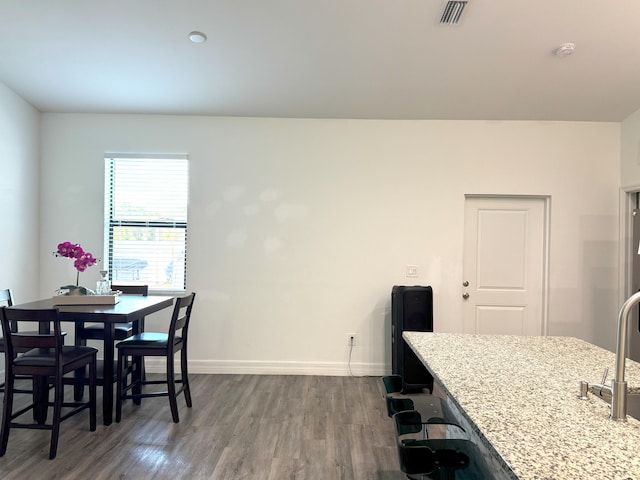 dining room featuring dark wood-style flooring, visible vents, and baseboards