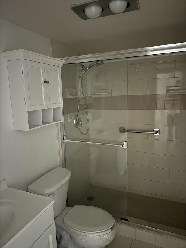 bathroom with a stall shower, vanity, and toilet